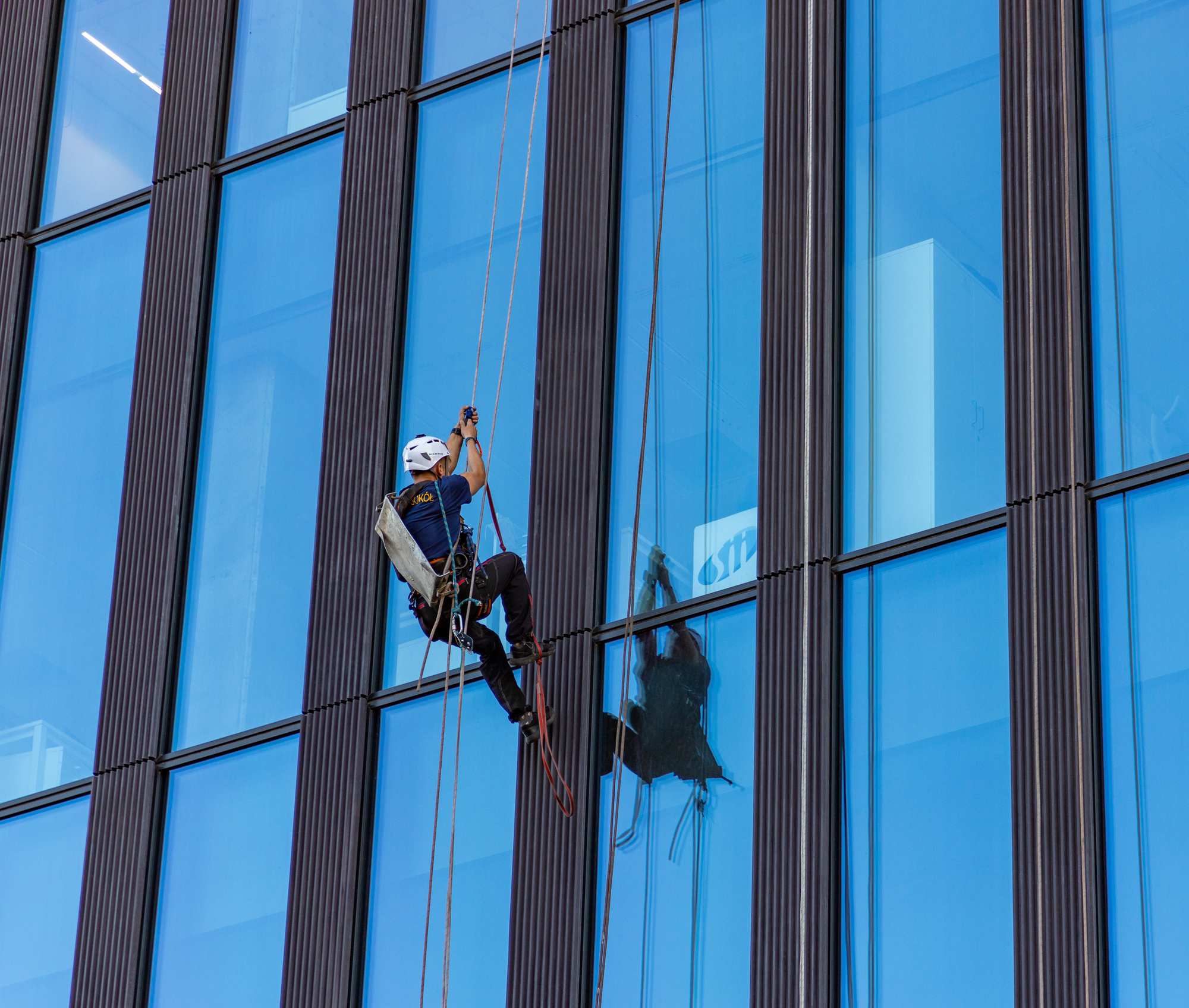 A picture of a window cleaner climbing an office building.